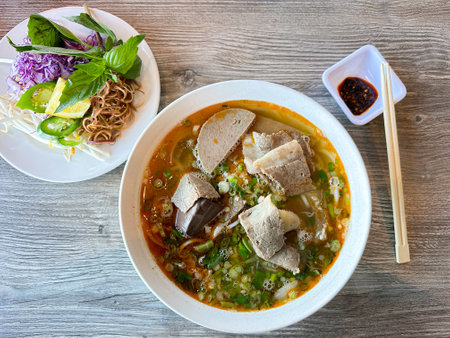 Top down view of Bun Bo Hue a Vietnamese spicy beef and pork noodle soup with spicy chili oil sauceの写真素材
