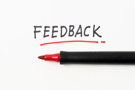 Hand writing Feedback with black marker and underline with red marker isolated on white backgroundの写真素材