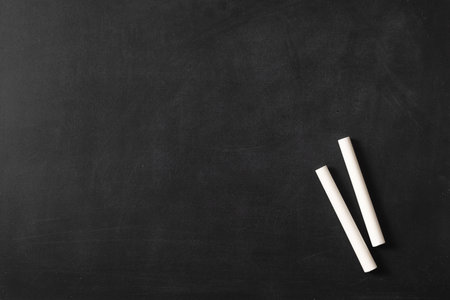Chalkboard wall texture. A black or dark gray chalkboard surface with a slightly rough texture with white chalks used for educational or creative designsの写真素材