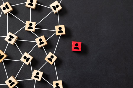 Wooden block cubes connected together with a red cube icon on a black background. Leadership, outstanding and teamwork concept in an organization.の写真素材