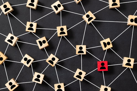 Wooden block cubes connected together with a red cube icon on a black background. Leadership, outstanding and teamwork concept in an organization.の写真素材