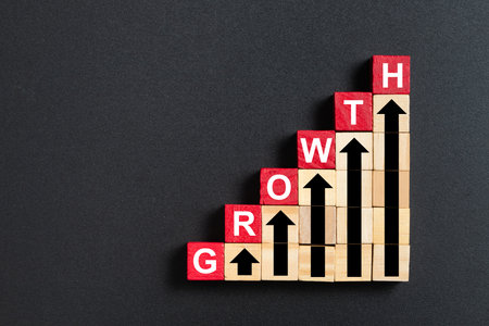 A stack of red wooden blocks with growth word for business, sales, revenue or investment growing conceptの写真素材