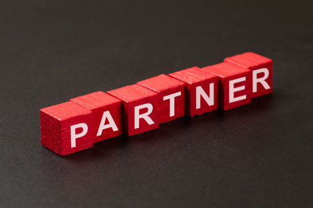 Partner word written in red wooden cube blocks isolated on black chalkboardの写真素材