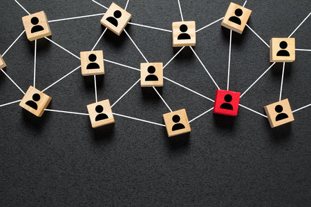 Wooden block cubes connected together with a red cube icon on a black background. Leadership, outstanding and teamwork concept in an organization.の写真素材