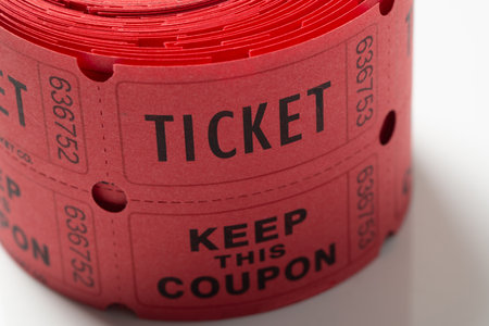 Close up roll of red tickets used for entrance into an event or entertainment isolated on white backgroundの写真素材