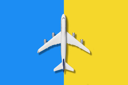 Miniature model airplane on blue and yellow pastel color background, flat lay designの写真素材