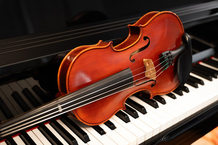 Violin on top of piano keyboard background with copy space for music concept or orchestra concert performance.の写真素材