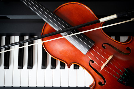 Violin on top of piano keyboard background with copy space for music concept or orchestra concert performance.の写真素材