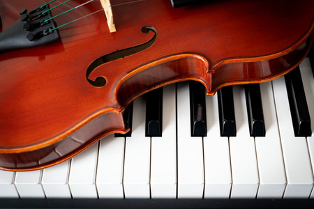 Violin on top of piano keyboard background with copy space for music concept or orchestra concert performance.の写真素材