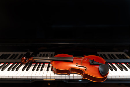 Violin on top of piano keyboard background with copy space for music concept or orchestra concert performance.の写真素材