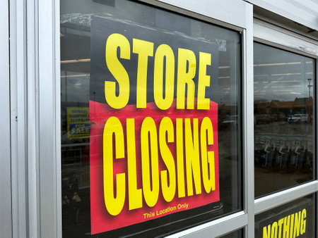 Retail store is going out of business with a large banner displaying store closing saleの写真素材
