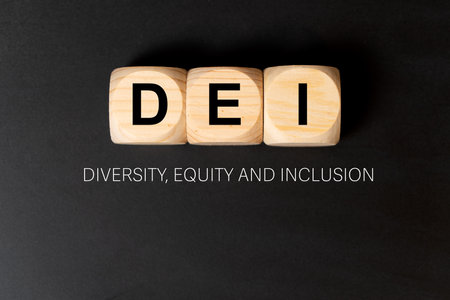 DEI letters written on three wooden cubes on black background, which means diversity, equity and inclusion.の写真素材