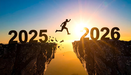 A man leaps across a chasm from a cliff marked '2025' to one marked '2026' against a dramatic, bright sunrise. The image symbolizes new opportunities, challenge, and the transition of the New Year.の素材