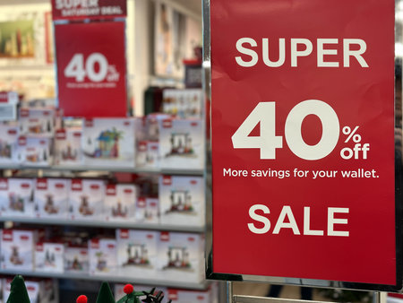 A red Sale 40 percentage off sign displayed in a retail store amidst Christmas decorations, highlighting holiday shopping deals and seasonal discounts.の写真素材