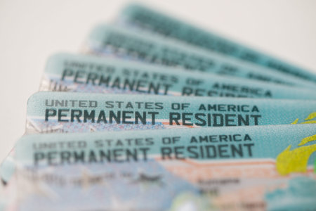 Close-up view of United States Permanent Resident cards stacked together. Concept of immigration,...