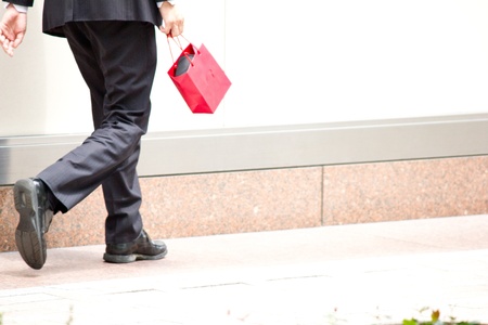 This is a picture of a businessman walking with a red bag I have taken in the spring の写真素材
