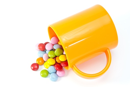 This is a picture of colorful chocolate and mug placed on the table.の写真素材