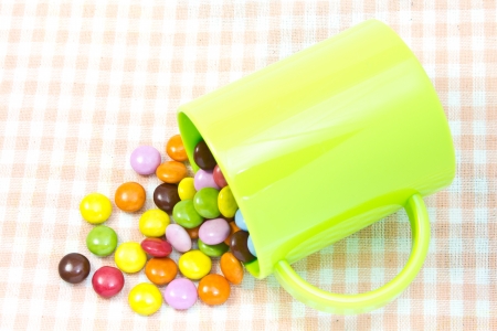 This is a picture of colorful chocolate and mug placed on the table.の写真素材