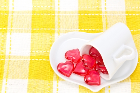 This is a picture of a red hearts and heart shaped cup on the table.の写真素材