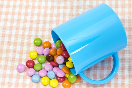 This is a picture of colorful chocolate and mug placed on the table.の写真素材