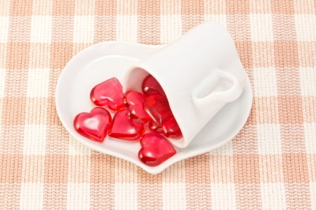 This is a picture of a red hearts and heart shaped cup on the table.の写真素材
