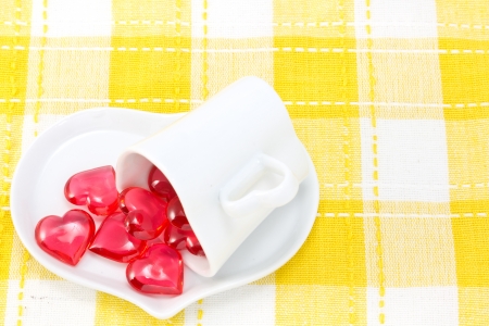 This is a picture of a red hearts and heart shaped cup on the table の写真素材