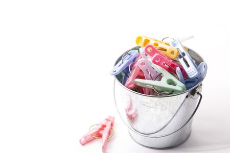 These are colorful clothespins that were placed in a bucket of tin.の写真素材