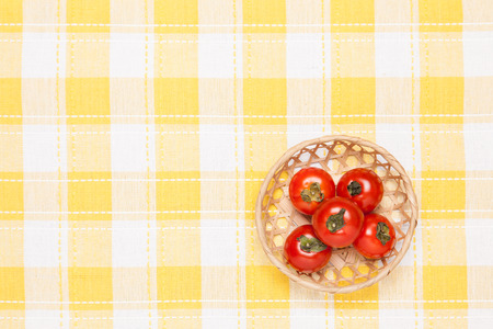 These are the tomatoes on the table and put it in a basket. の写真素材