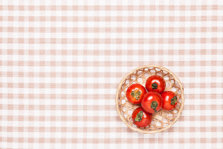 These are the tomatoes on the table and put it in a basket. の写真素材
