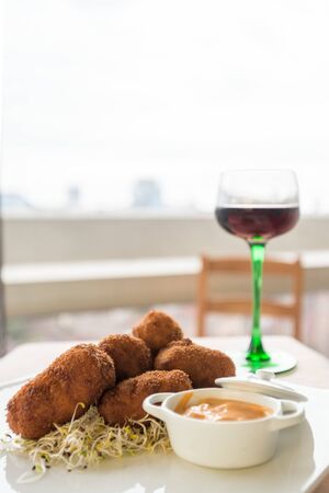 A dish of croquettes and a glass of wineの写真素材
