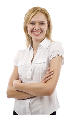 Beautiful young businesswoman standing with hands folded against white backgroundの写真素材