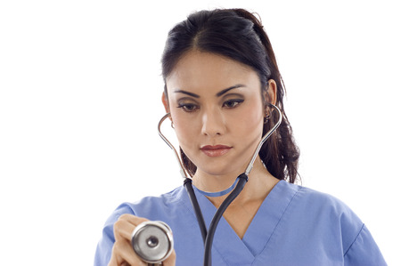 Young Asian woman nurse holding a stethoscope isolated over white backgroundの写真素材