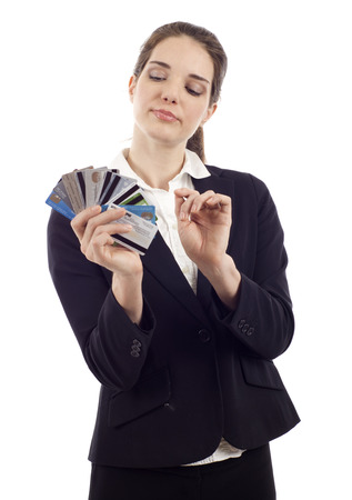 Beautiful young woman choosing which credit card to pay with, isolated over whiteの写真素材