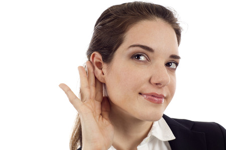 Woman listening with her hand on an ear isolated over white backgroundの写真素材