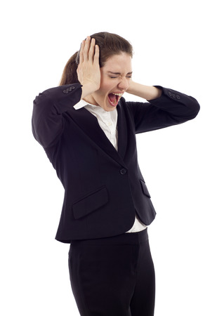 Beautiful young business woman screaming, Hands at her ears, mouth wide open, eyes closed isolated over white backgroundの写真素材