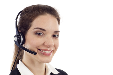 Closeup of a beautiful business customer service woman smiling with copyspace isolated over whiteの写真素材