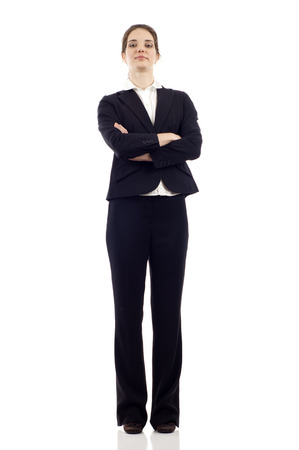Full length of a confident young business woman standing with folded hands isolated on white backgroundの写真素材