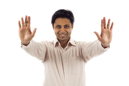 Indian man with his hands raised in signal to stopの写真素材