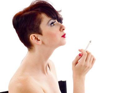 Vogue style - fashion model smoking  in a chair isolated over whiteの写真素材