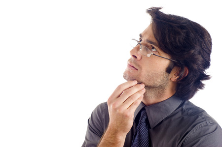 Business man  in deep thought looking up at copyspace isolated over whiteの写真素材