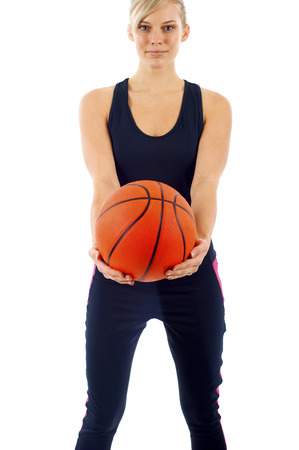 Attractive young woman holding a basketball isolated over white backgroundの写真素材