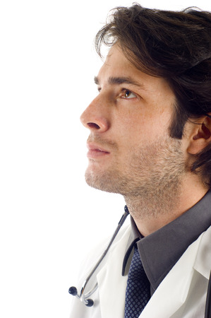 Closeup of young medical doctor in deep thought, Isolated over a white backgroundの写真素材