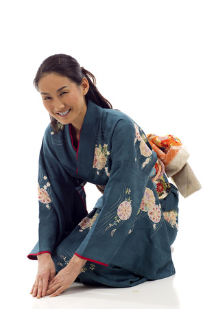 Smiling Japanese kimono woman bowing isolated over white backgroundの写真素材