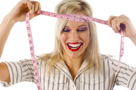 Woman Laughing and Putting Measuring Tape Around her Headの写真素材