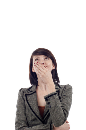 Surprised young lady looking up at copyspace isolated white backgroundの写真素材