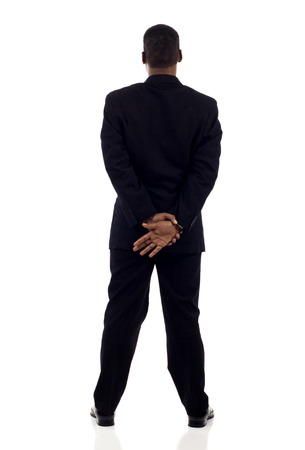 Full length of an African American business man standing, hands together back view isolated over whiteの写真素材