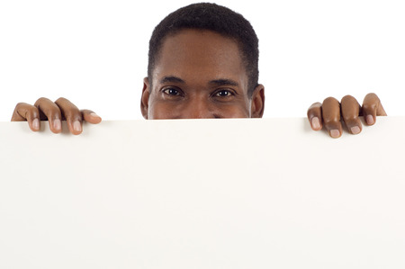 Happy smiling African American man holding a banner ad, sign showing only his eyes isolated over white backgroundの写真素材