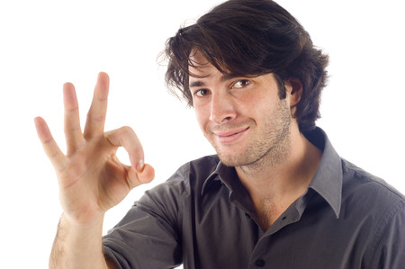 Young smart man indicating OK sign, isolated over white backgroundの写真素材
