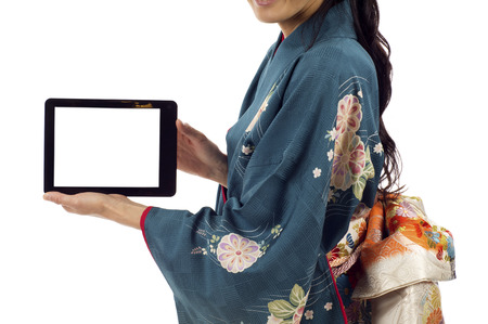 Japanese kimono woman holding a tablet pc isolated over white backgroundの写真素材