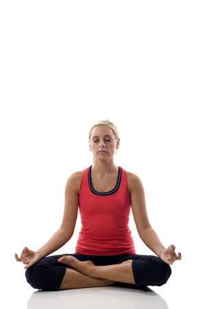 Lotus position - Portrait of a cute young female practicing yogaの写真素材